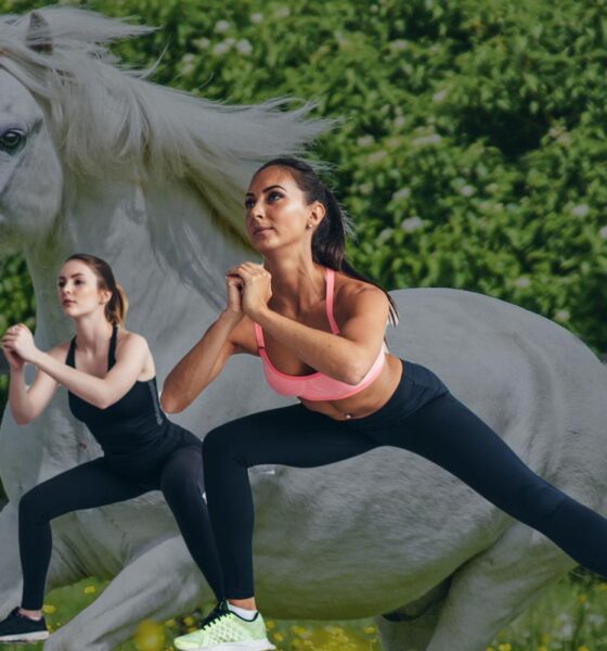 Two women doing exercise with a unicorn projected behind